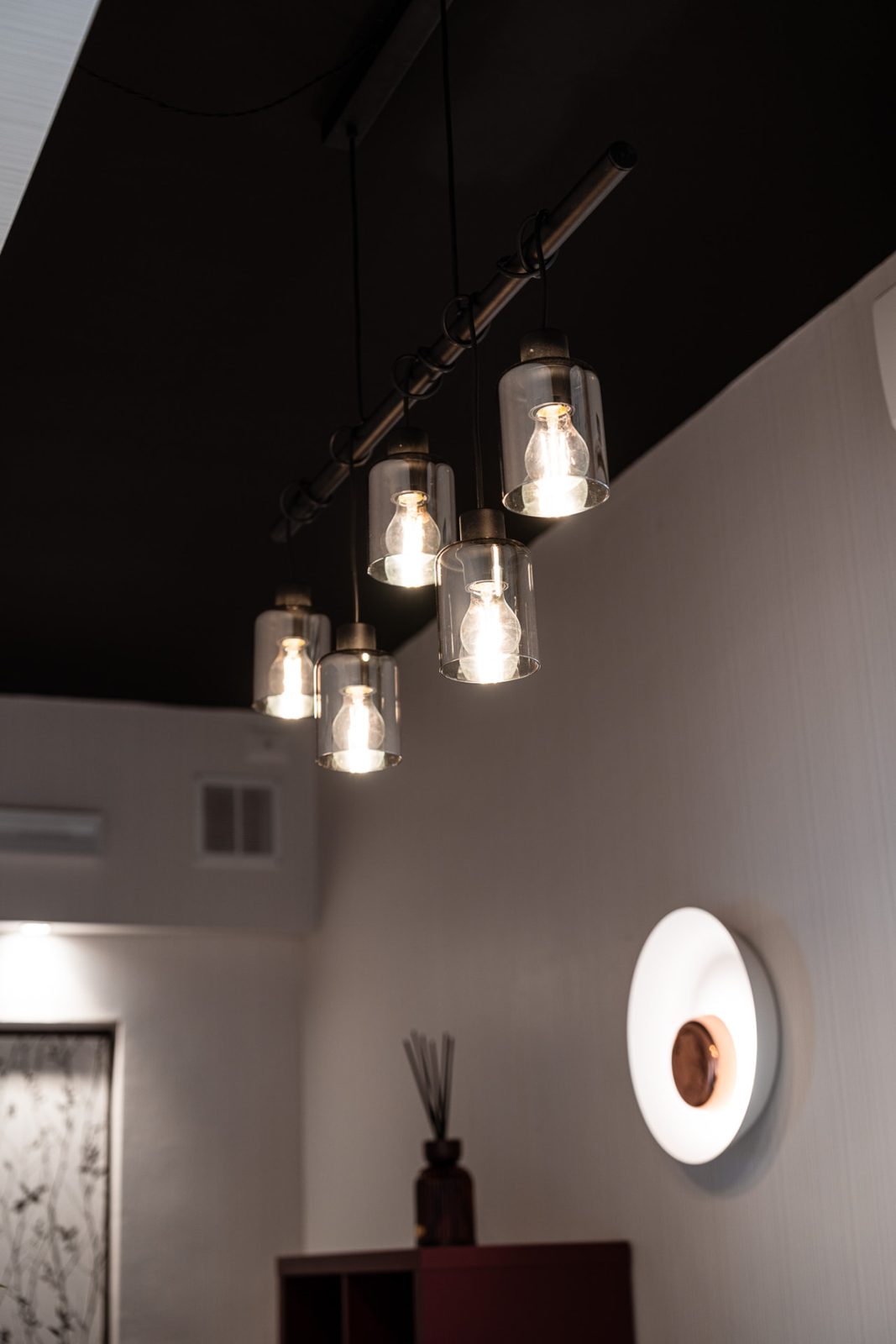 Lampade sospese in vetro e applique nel corridoio